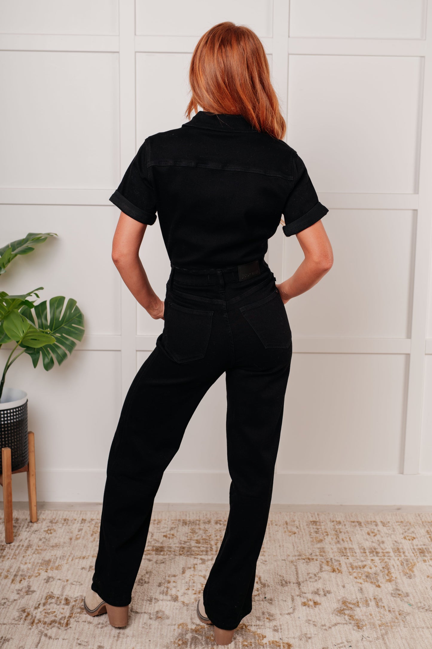 Back view of Timara Denim Jumpsuit with straight leg fit, short sleeves, and functional back pockets