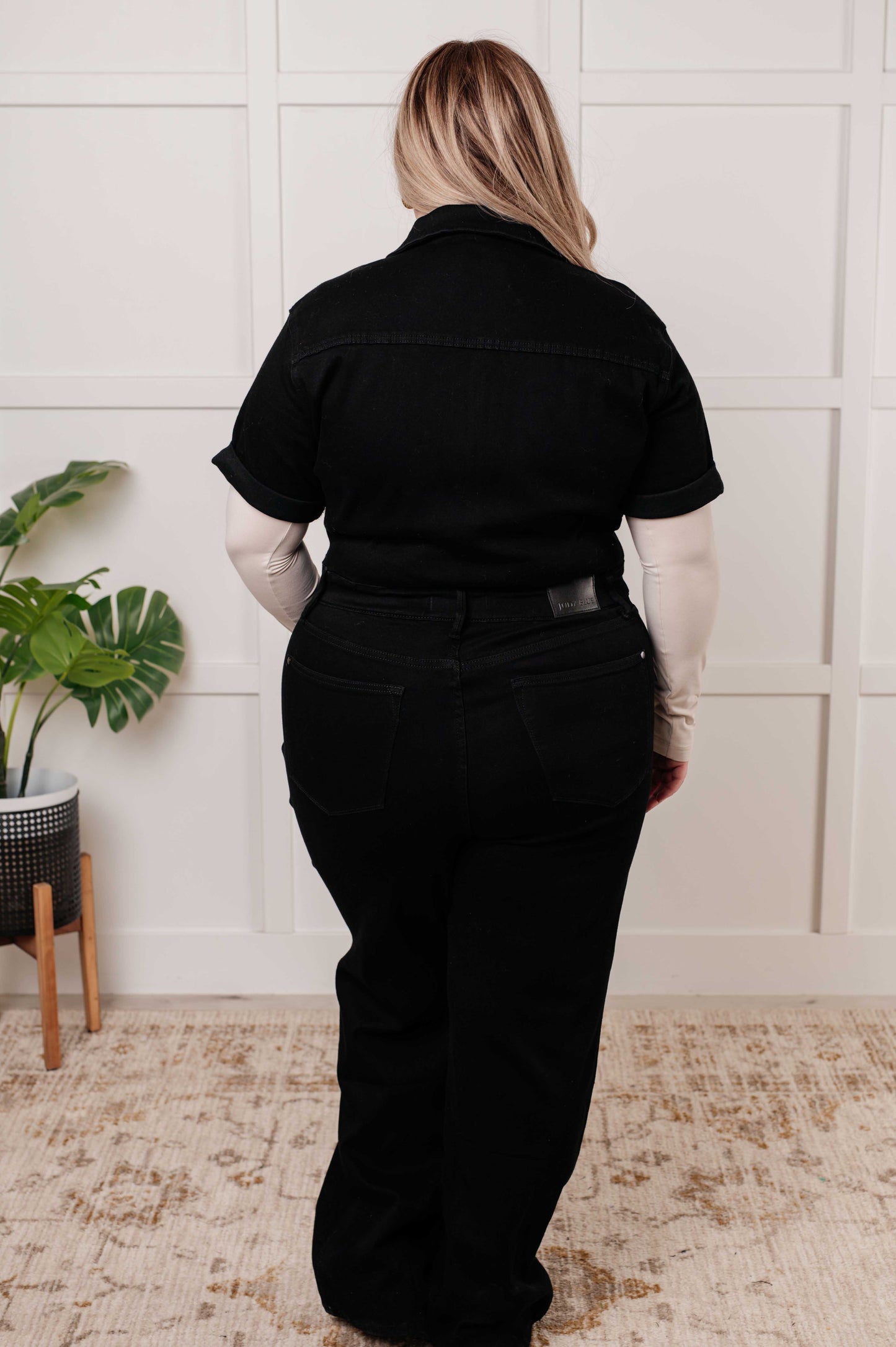 Plus size back view of Timara Denim Jumpsuit in black, straight-leg silhouette with flattering fit and back pockets