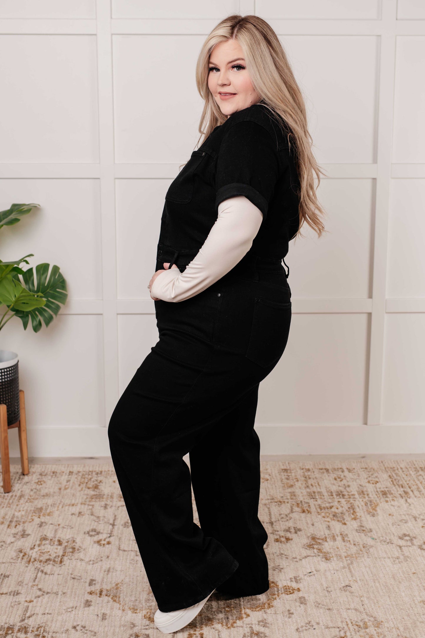 Plus size side view of Timara Denim Jumpsuit, garment-dyed black denim with zip front and elastic waistband