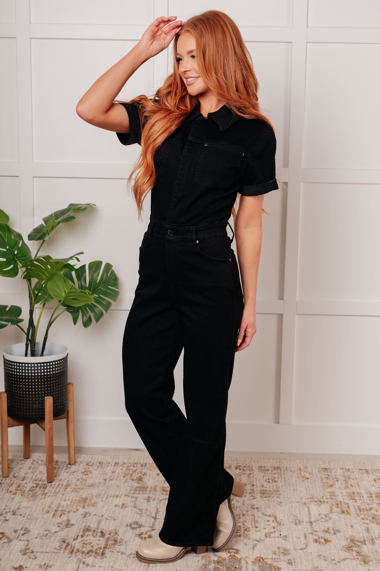Side angle of Timara Denim Jumpsuit in black showing collared neckline, short sleeves, and sleek straight leg