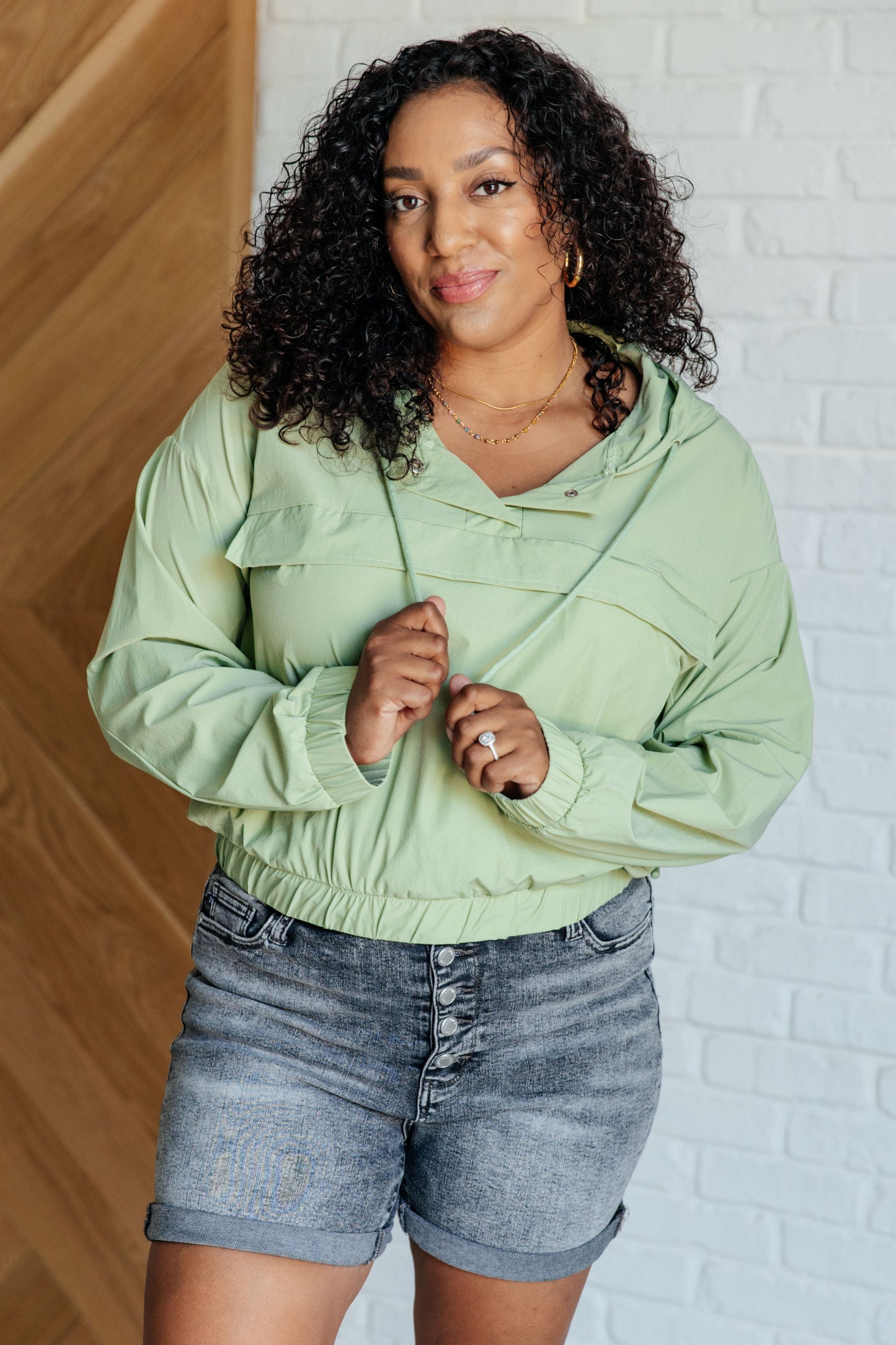 Plus size Jules Hooded Windbreaker in green, hooded nylon design with zip pocket and relaxed fit.