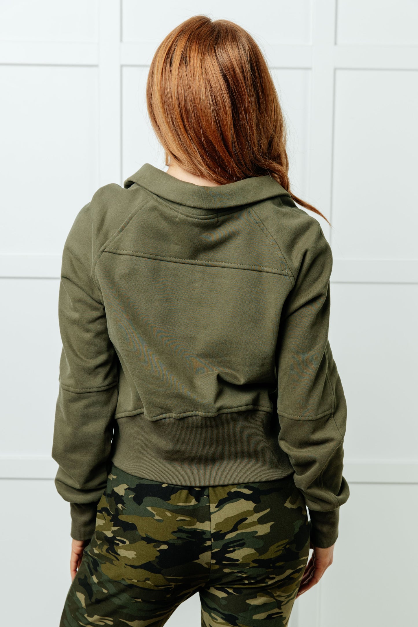 Model back view showing raglan sleeves and ribbed hem pullover in Green