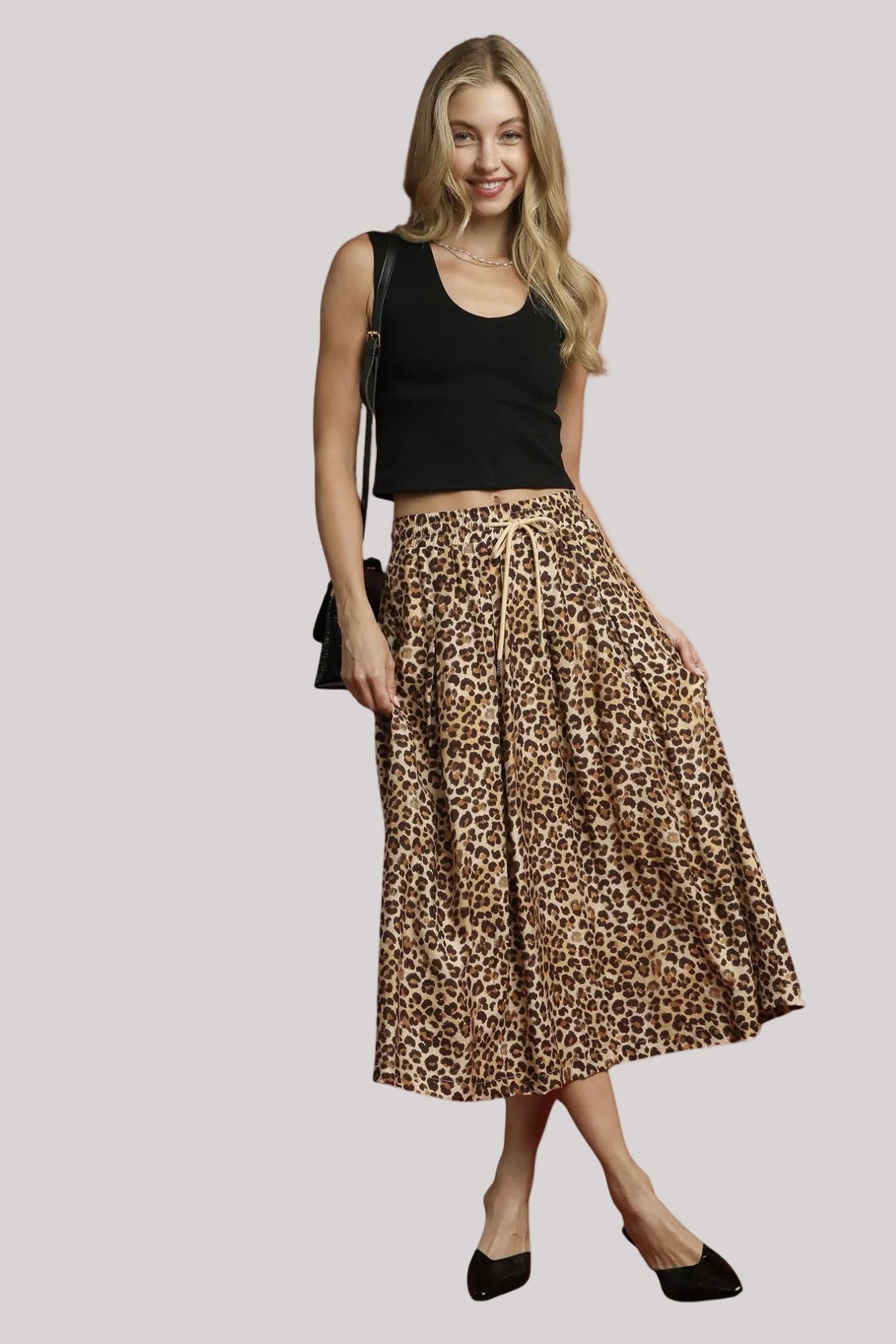 Woman styling Nala leopard midi skirt with casual chic outfit.