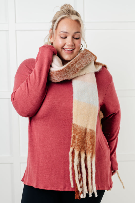 Plus size model wearing Wanderlust Wrap Oversized Plaid Fringe Scarf in light brown.