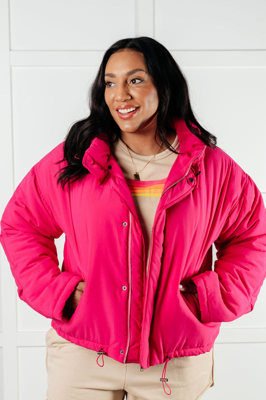 Plus size model wearing Reggie Puffer Jacket in Pink with zip-snap closure and toggle waistband.