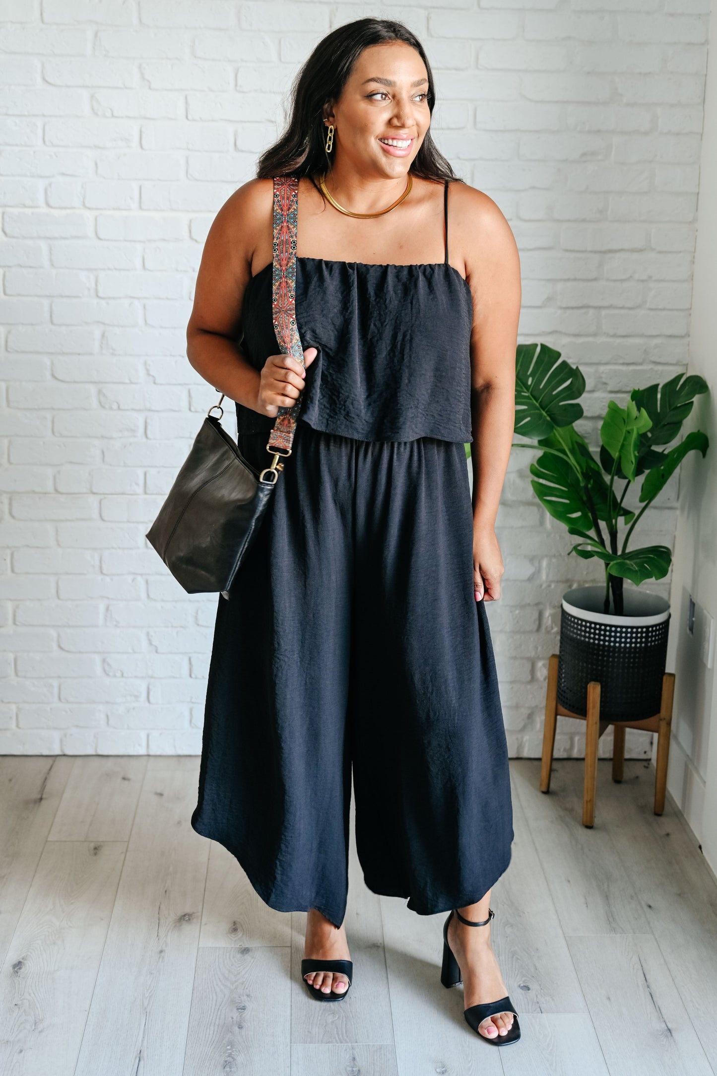 Full body view of plus size Sahar Black Jumpsuit with adjustable straps and functional pockets.