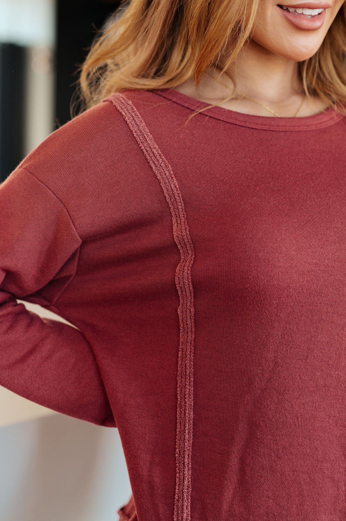 Close-up of Taya Pullover highlighting exposed seams and reverse fabric detail in lightweight French terry.