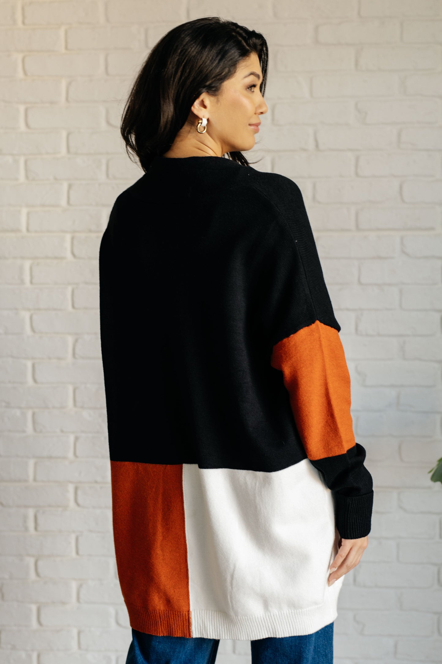 Model back view Jackie color block cardigan in black, orange, and white