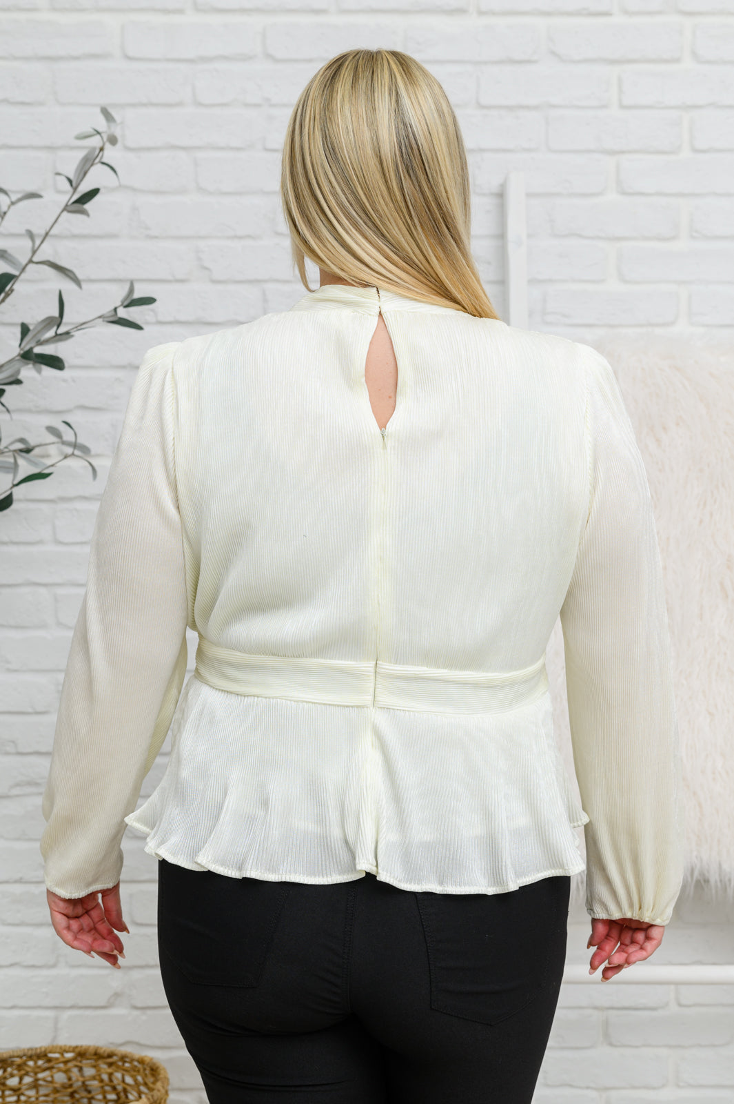 Plus size back view of Xanidu Plissé Blouse in white showing zipper closure and peplum silhouette.