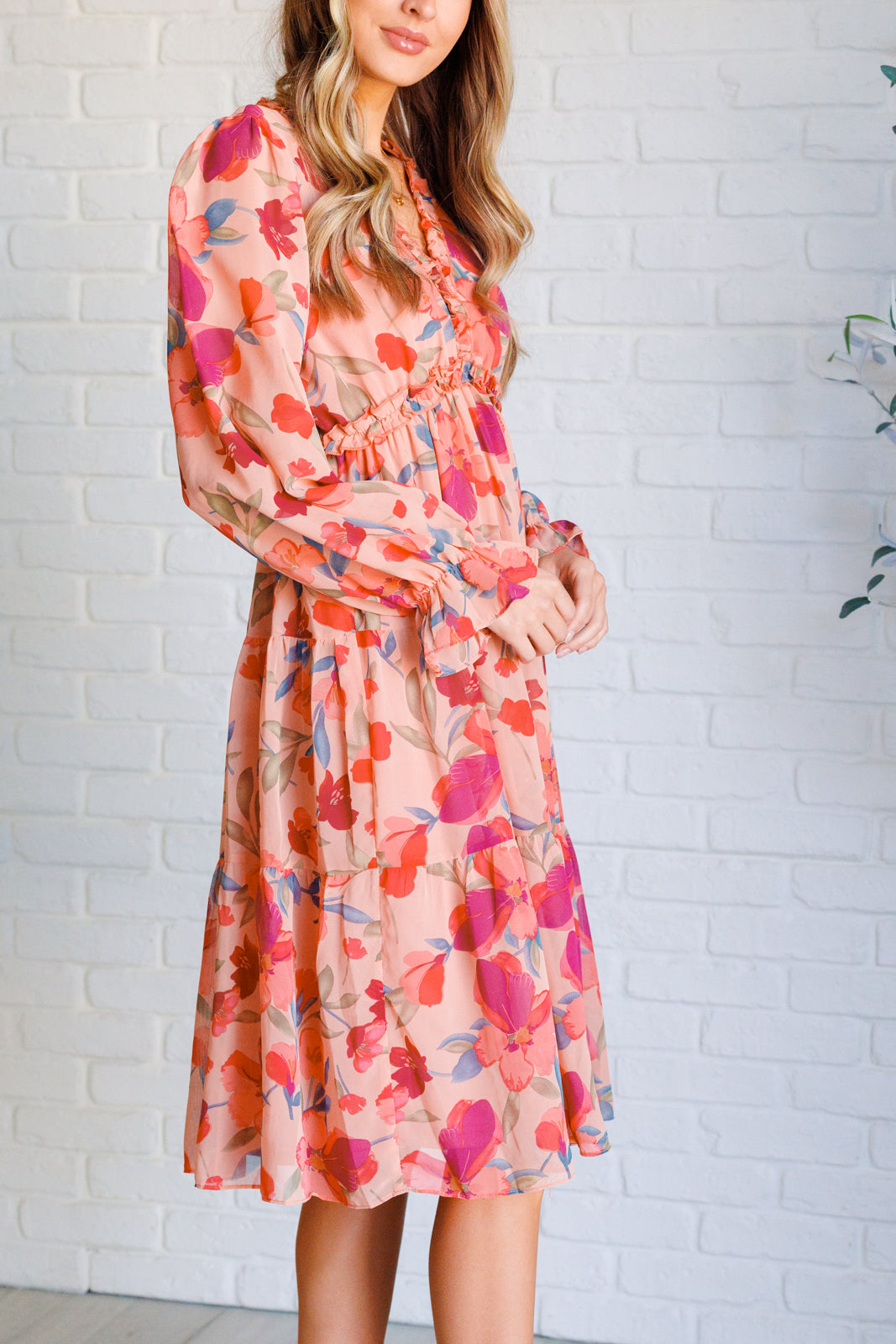 Side view of Maci Floral Midi Dress showing flowy peach floral chiffon and flattering empire waistline