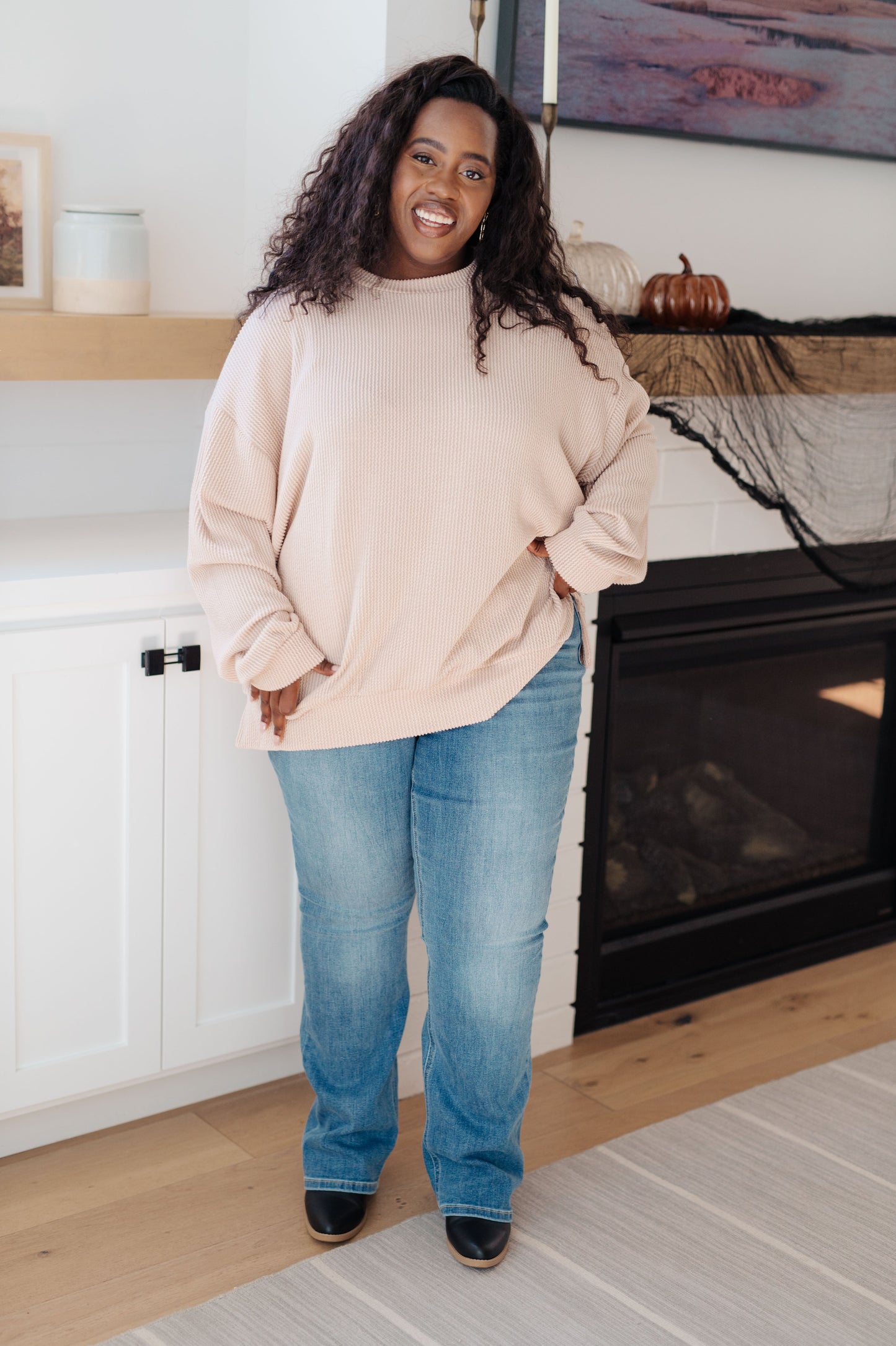 Plus size model in Holly Pullover paired with jeans and boots.