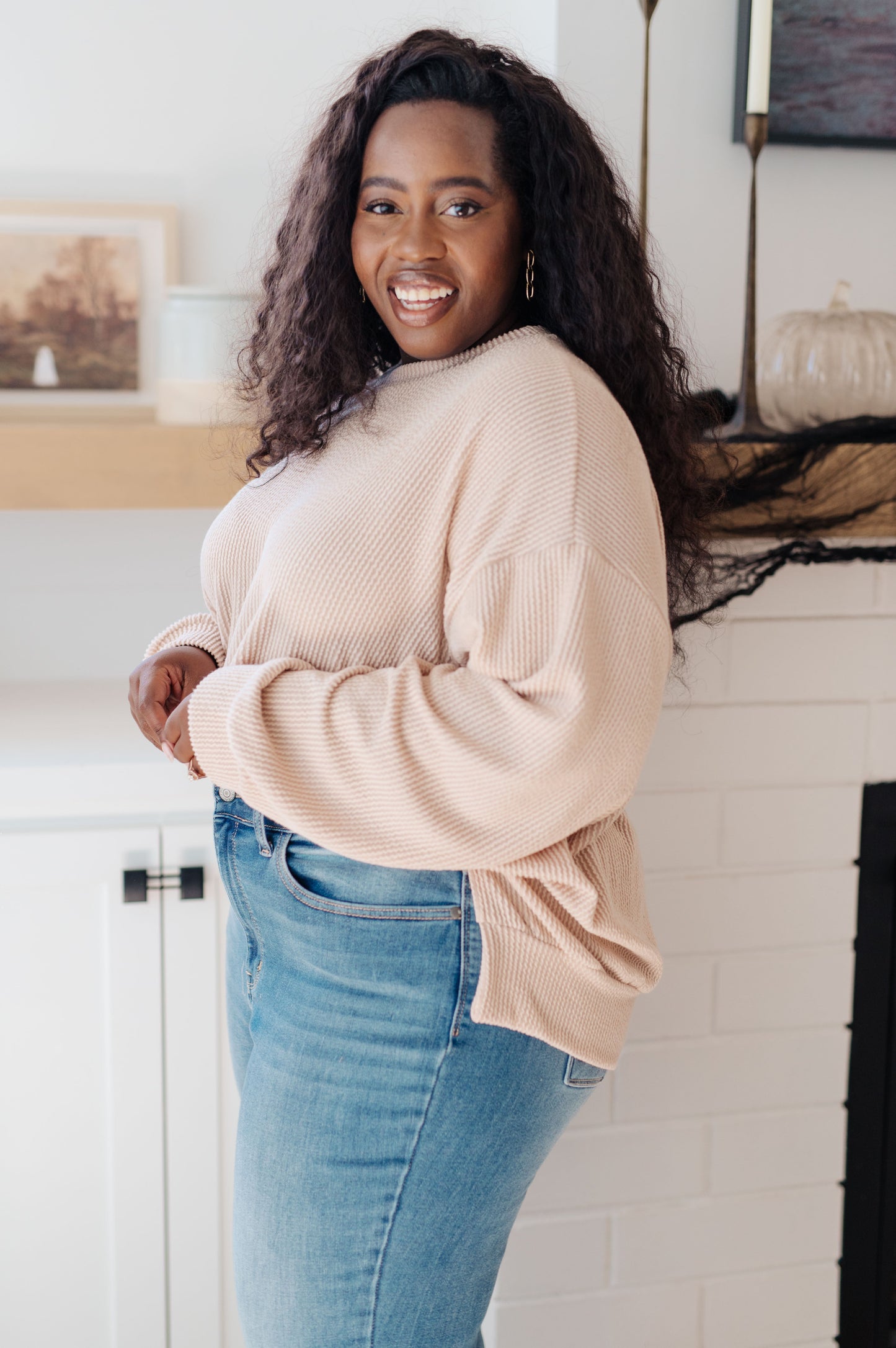 Side angle of plus size model wearing Holly Pullover with slit hem and ribbed texture.