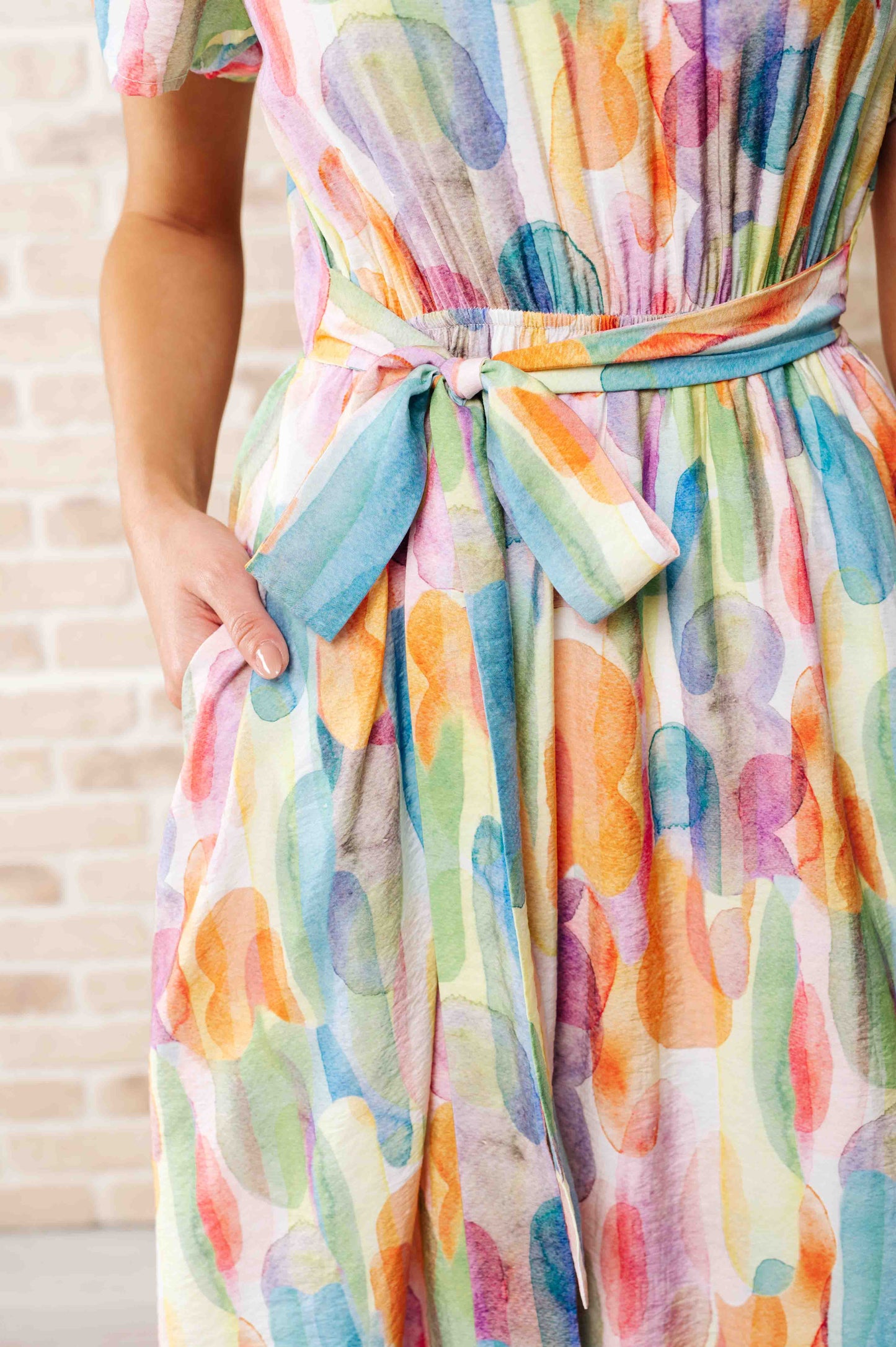 Close up of Yuna Dress showing watercolor print fabric and bow detail at the waist tie.