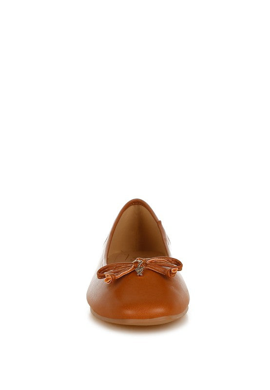 Front view of tan vegan leather ballerinas with bow detail, round toe, and cushioned insole for stylish everyday comfort.
