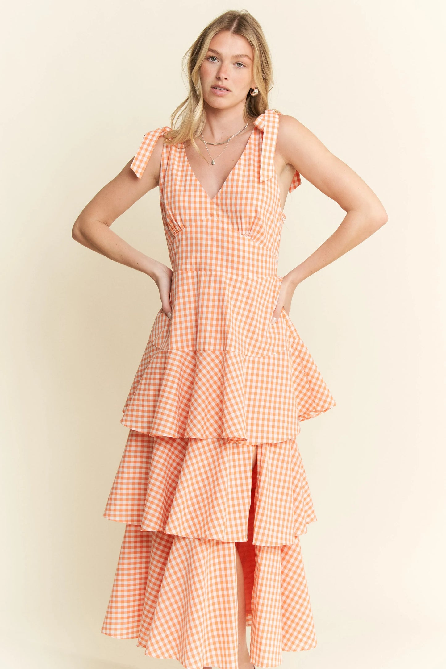Front view of Alice Gingham Midi Dress highlighting cute green and white gingham print, tiered ruffle design, and sleeveless silhouette.