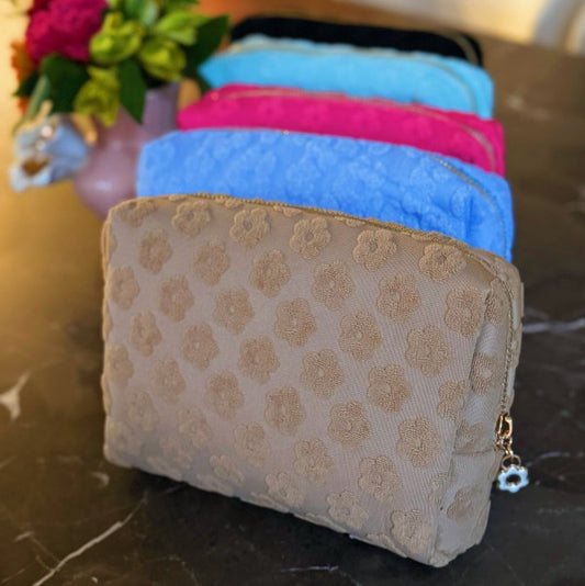 Group view of Embossed Daisy Blossom Cosmetic Cases in all color options.