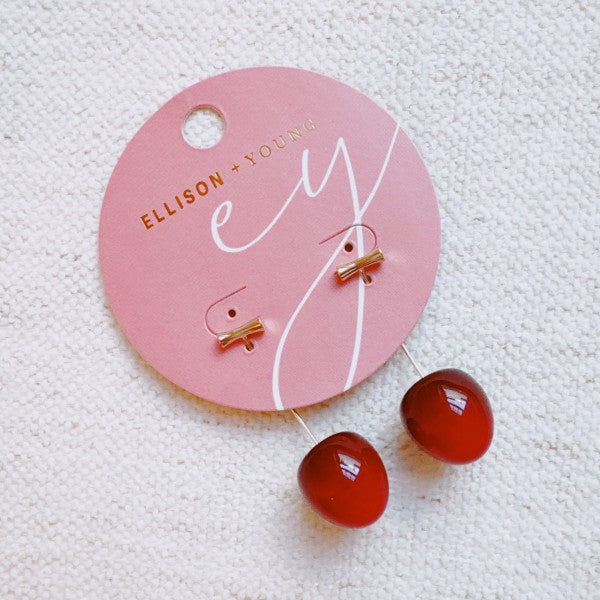 Sweet Cherry Earrings on pink Ellison + Young card packaging with gold lettering