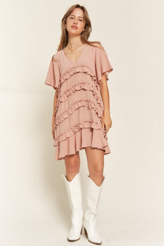 Full body view of model wearing Gentry Tiered Ruffle Mini Dress in mauve, paired with casual sandals.