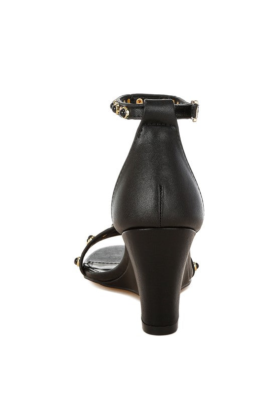 Back view black leather sandals with slim wedge heel and studs.