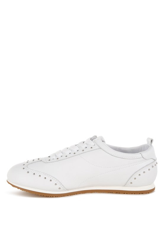 Side view of white Odaya Studded Leather Sneakers by Rag Company, showing stud embellishments, flatform sole, and lace-up design.