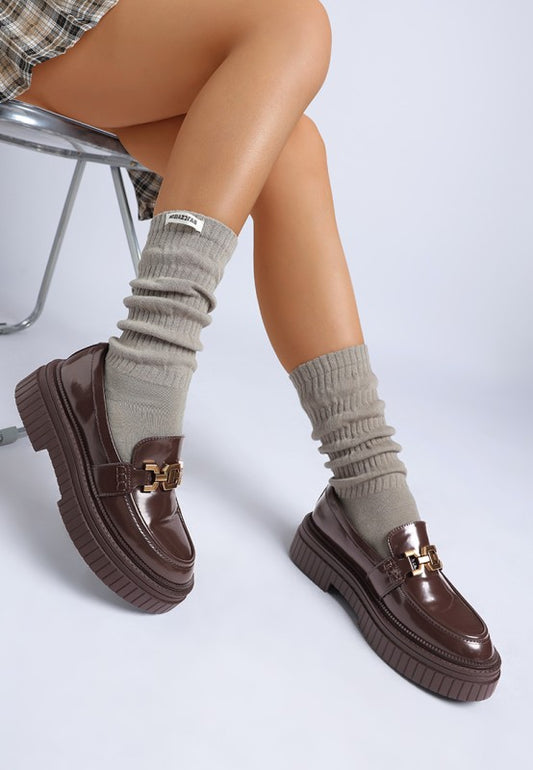 Model seated showing brown Grosbeak Horsebit Chunky Loafers.
