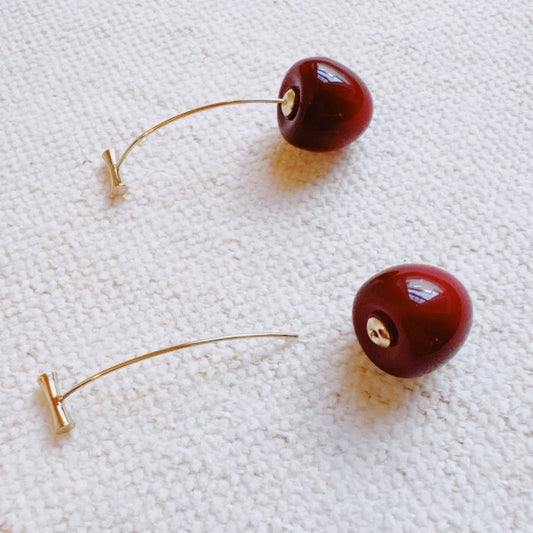 Cherry earrings showcasing unique bar stud and curved gold wire closure detail