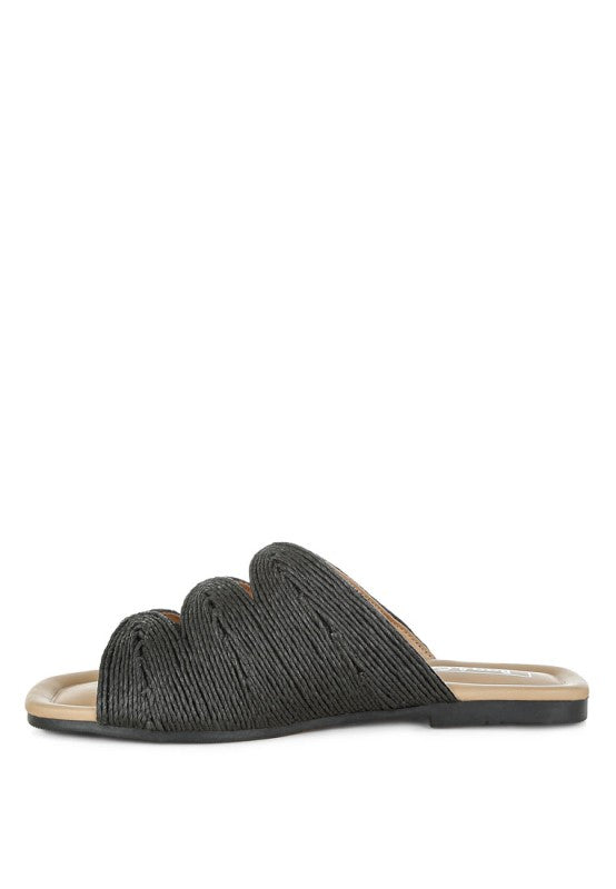 Inside side view of black Daisy Doe raffia flat showing the slip-on design, cushioned insole, and raffia texture.