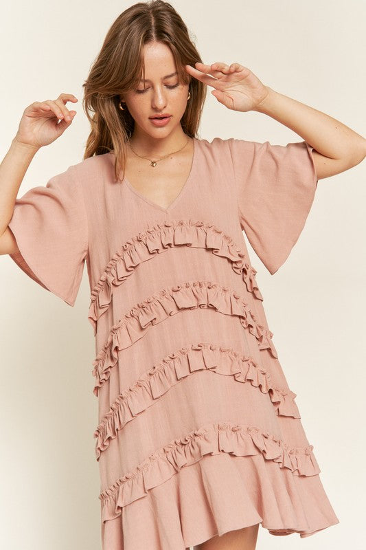 Front view of model wearing Gentry Tiered Ruffle Mini Dress in mauve, styled with summer accessories.