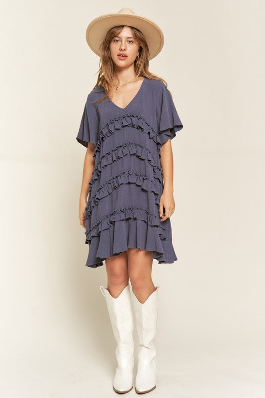 Full body view of model wearing Cement Gentry Curvy Tiered Ruffle Mini Dress, styled with boots for a summer look.