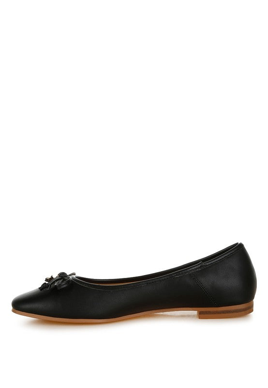 Side view of black vegan leather flats with bow accent, cushioned insole, and flat heel for all-day comfort.