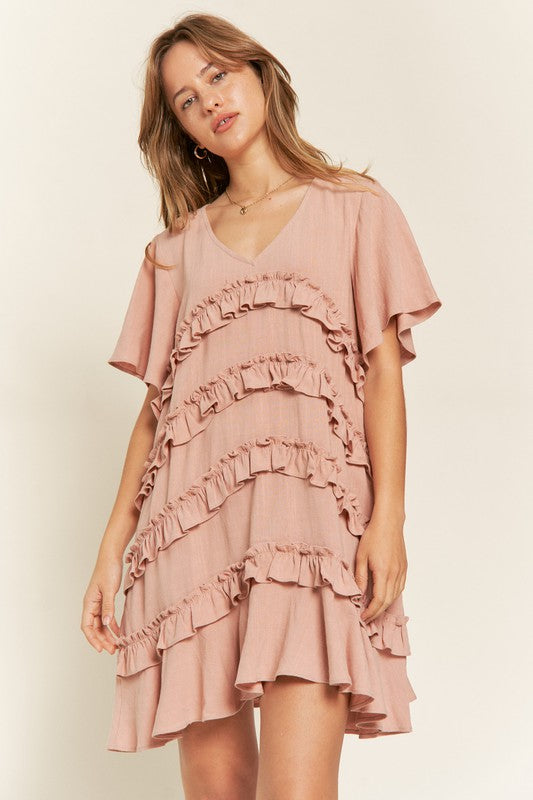 View of model in Mauve Gentry Curvy Tiered Ruffle Mini Dress, showing ruffle trim and tiered skirt.