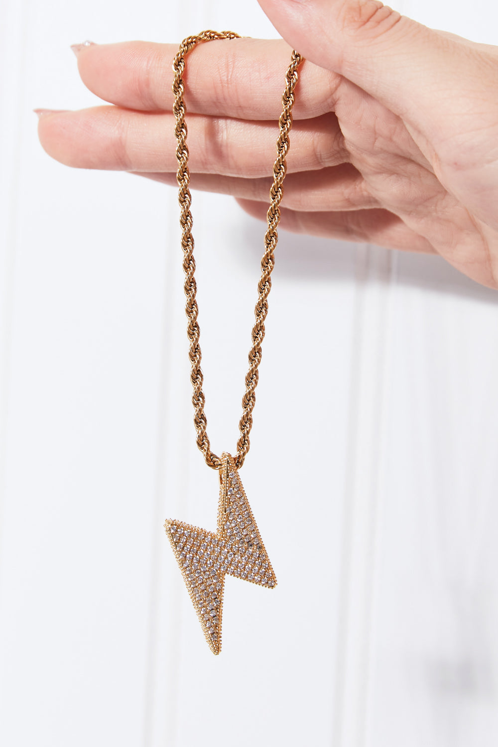 Lightning pendant necklace with a twisted chain, crafted from brass, stainless steel, and cubic zirconia for a sparkling touch.
