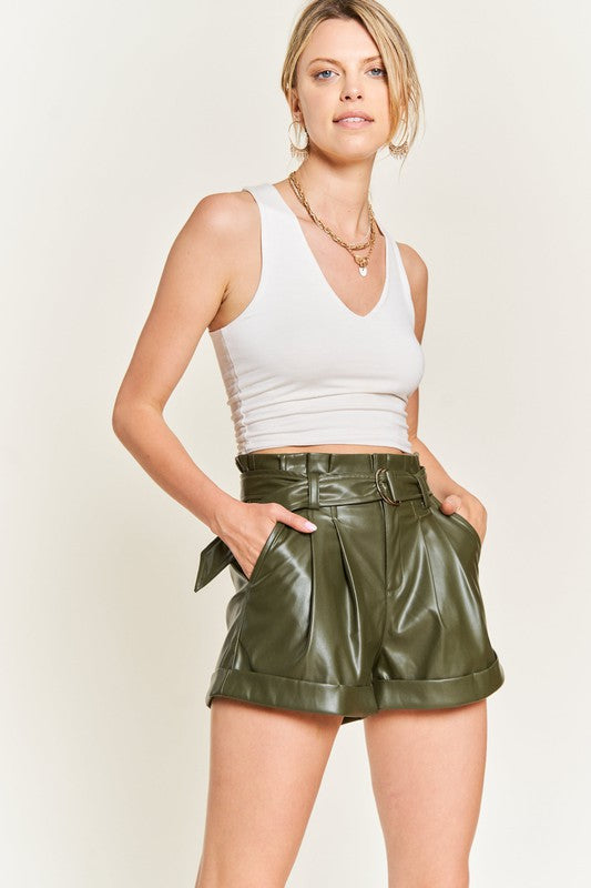 Front view of Larissa high-rise faux leather shorts with paper bag waist, D-ring belt, and slanted pockets in olive.