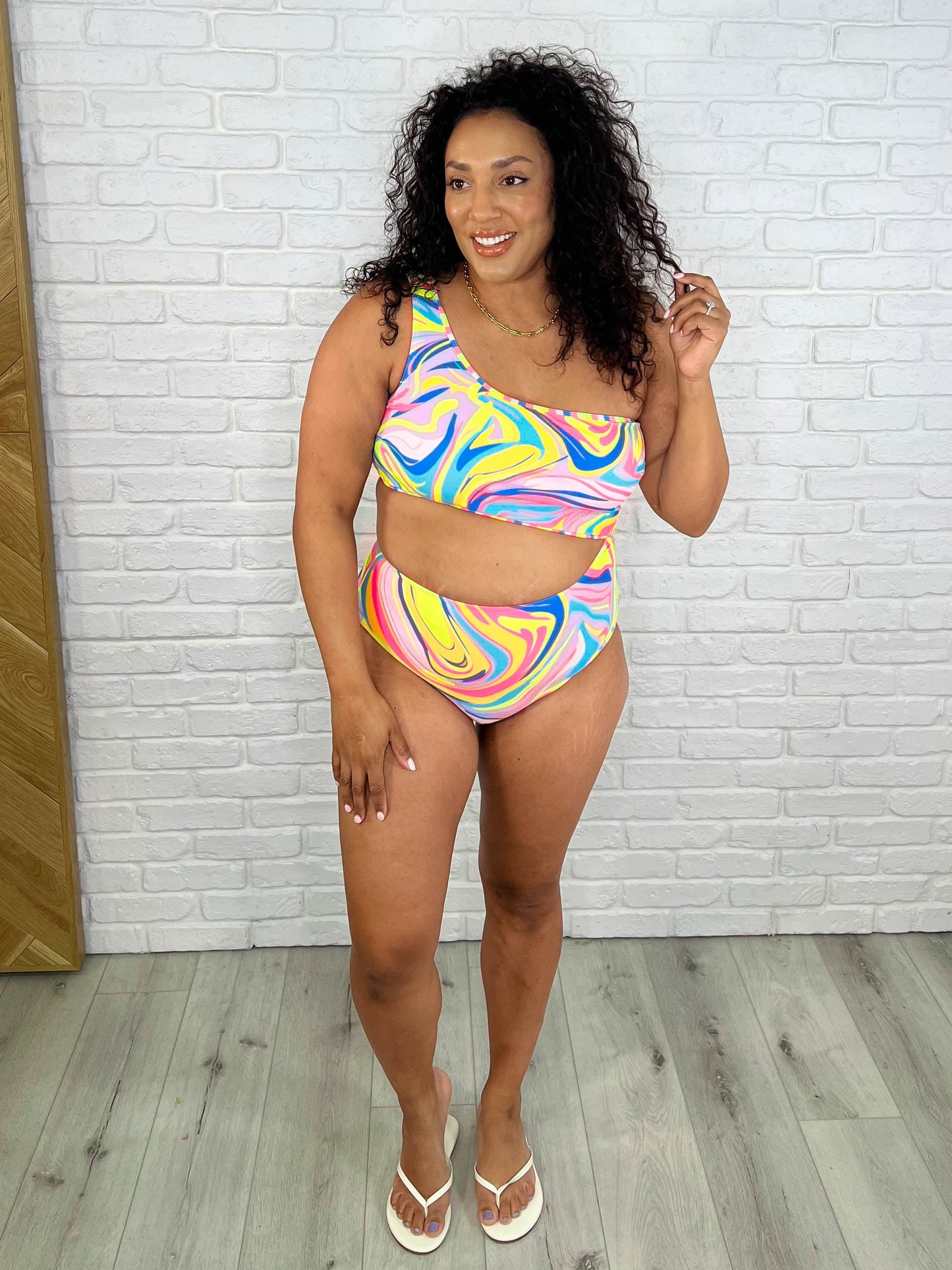Bold and playful Corfu Swimsuit featuring a bright marble print, asymmetrical one-shoulder neckline, removable cups, and cheeky fit for a trendy summer look.