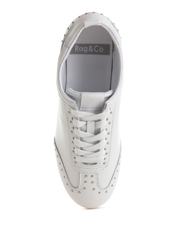 Top view of white Odaya Studded Leather Sneakers by Rag Company, highlighting lace-up detail, cushioned insole, and stud embellishments.