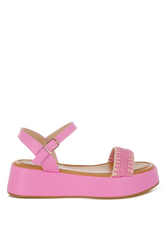 Side view of pink woven raffia flatform sandals featuring soft cushioned footbed and round open toe design.