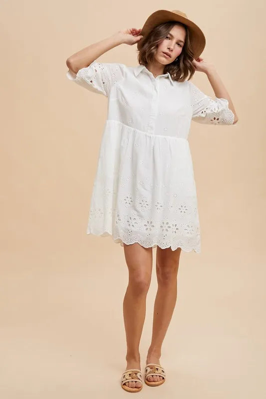 Full body view of model wearing the Kiaan Embroidered Mini Dress in ivory cotton eyelet with scalloped hem and collared neckline.