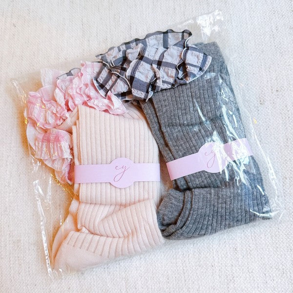 Packaged Plaid Ruffle Bow Socks Set of 2 with pink and grey variants.