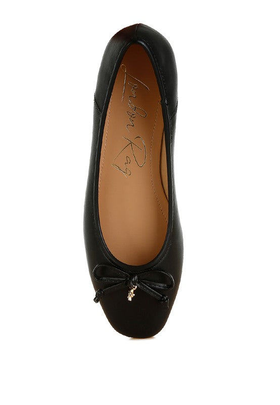 Top view of black vegan leather ballerinas with bow detail and round closed toe in classic vegan leather.