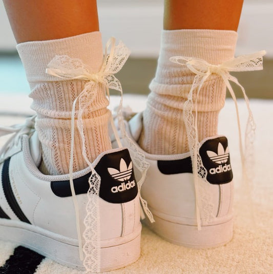Woman wearing white Lace & Satin Bow Socks styled with sneakers, bow detail at back.