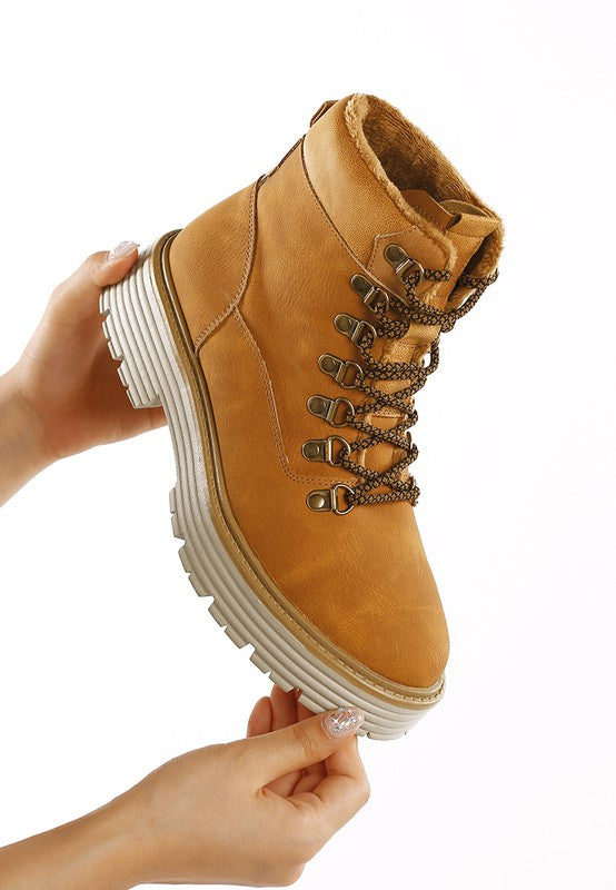 Woman holding single Tan Boskoff Lace-Up Chunky Ankle Boot showing lace-up design and chunky heel.