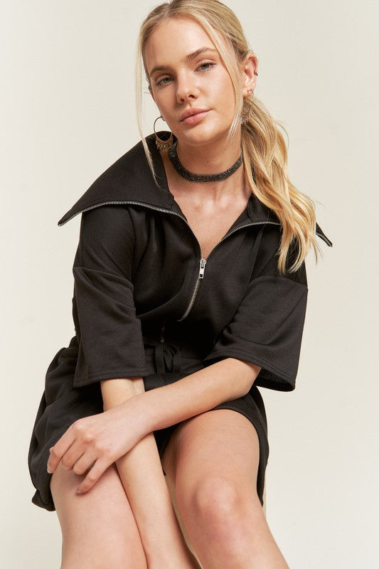 Sitting close-up of black Clover Plus Size romper with soft French terry fabric.