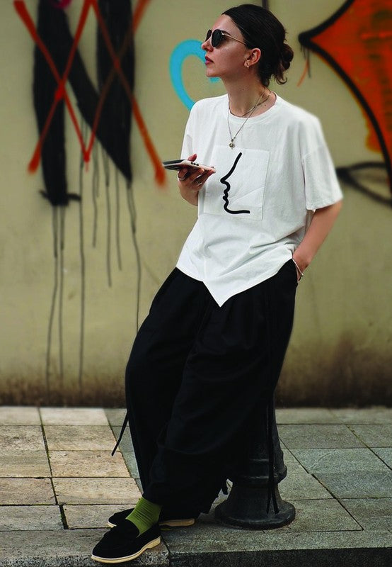 Woman wearing black Nautica suede loafers styled with relaxed streetwear.