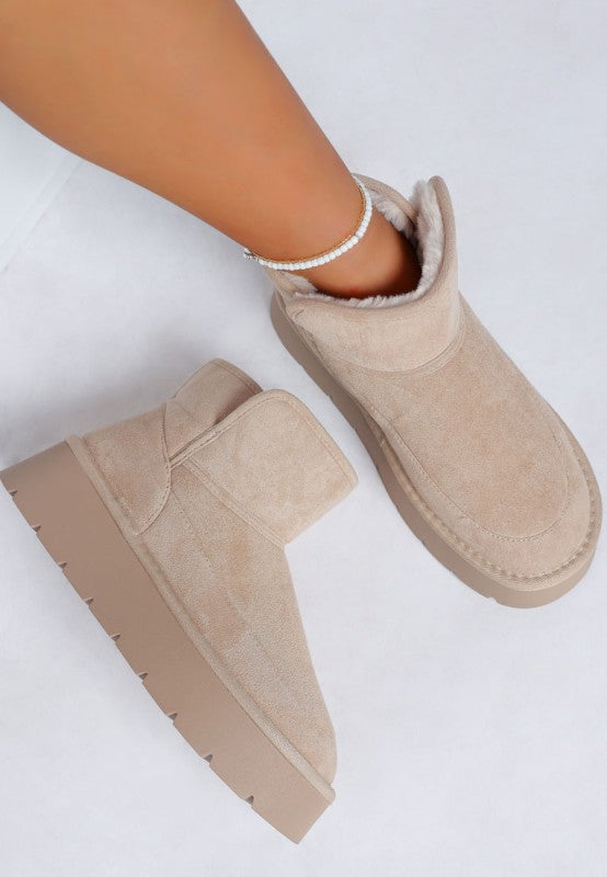 View of woman wearing Sand Holias Chunky Heeled Snow Boot with the other boot displayed for detail.