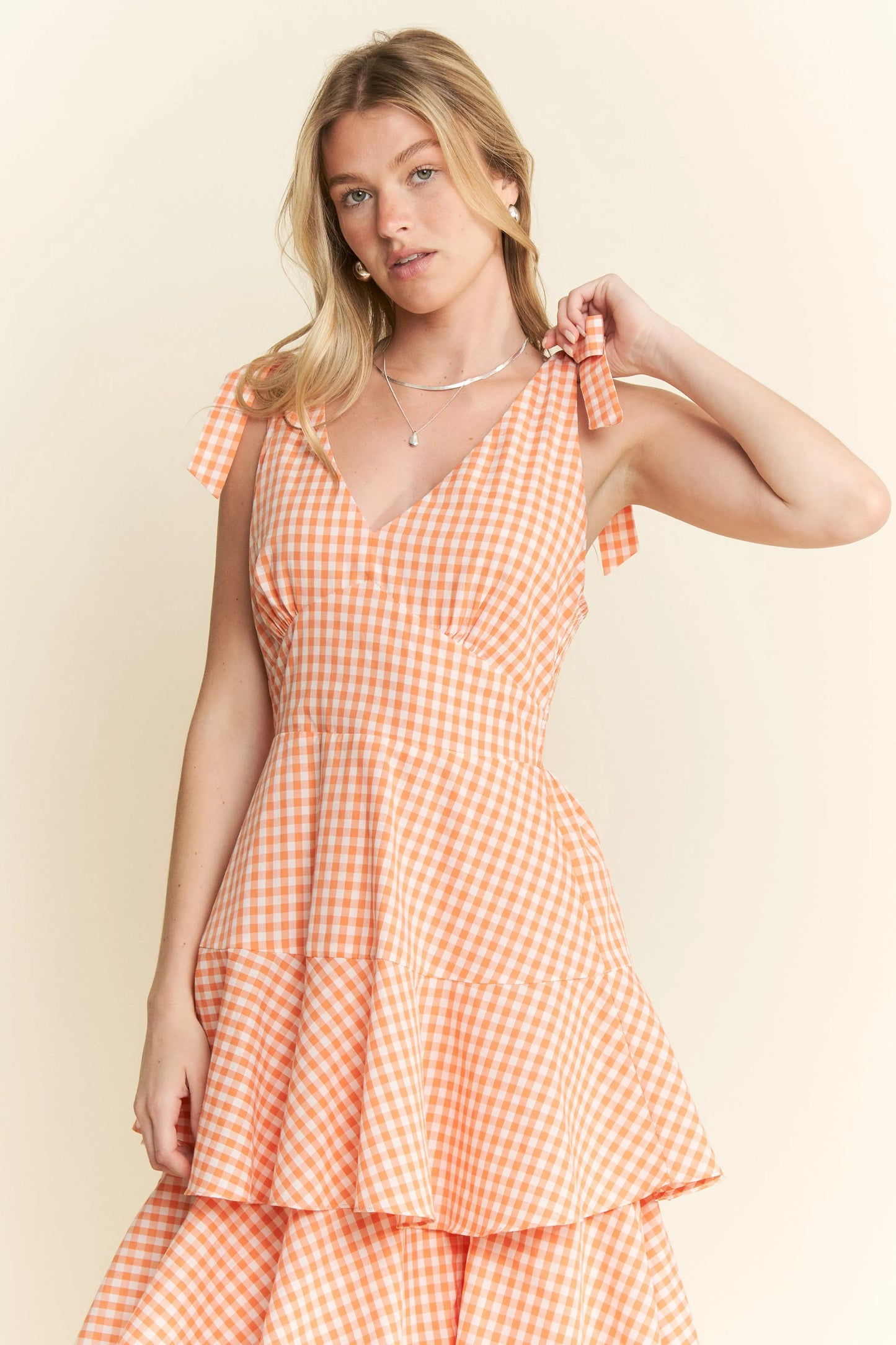 Close-up front view of Alice Gingham Tiered Midi Dress by Jade by Jane, showing V-neckline, gingham print, and tied shoulder strap detail.