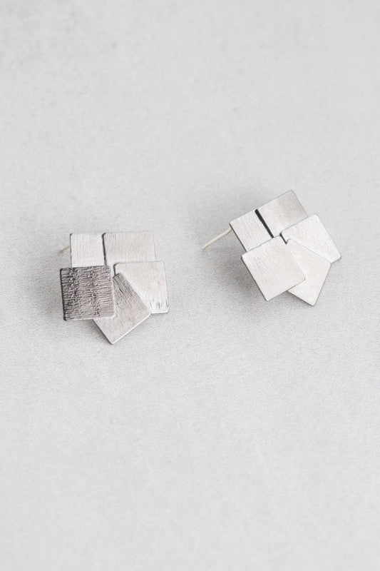 Flat lay of Square Deal Earrings showing layered geometric design.
