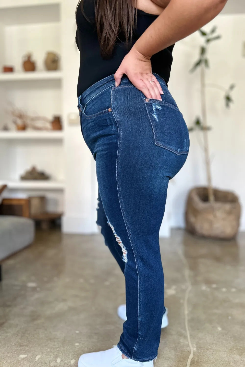 Side profile of plus size model in Wynna Straight Jeans, straight leg cut with distressed details