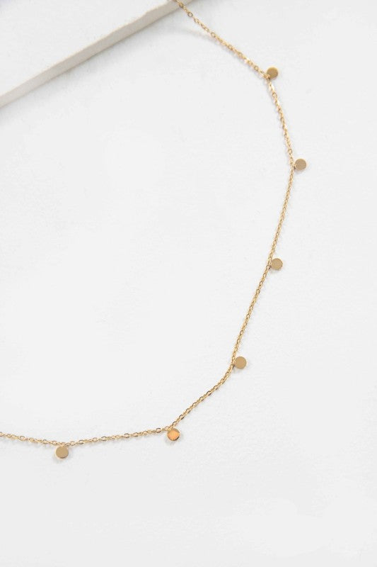 Close-up flat lay of Golden Dot Charm Necklace showing tiny gold discs