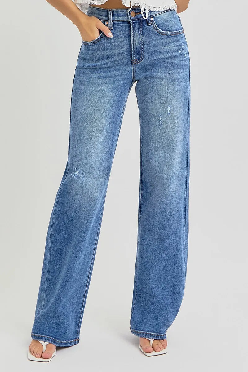 Plus size model wearing Allyson wide leg jeans in medium wash, hands relaxed at sides, showcasing high-rise fit and tummy control waistband.
