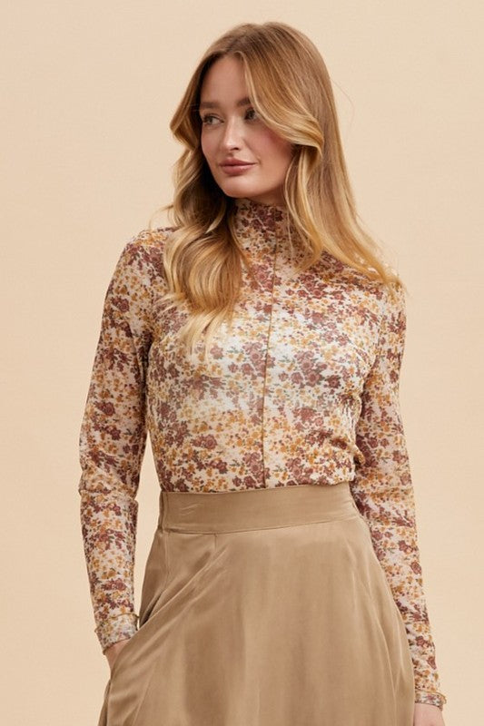 Elodie ivory/gold floral mesh top with mock neck and ruffle lettuce hem, styled for layering.